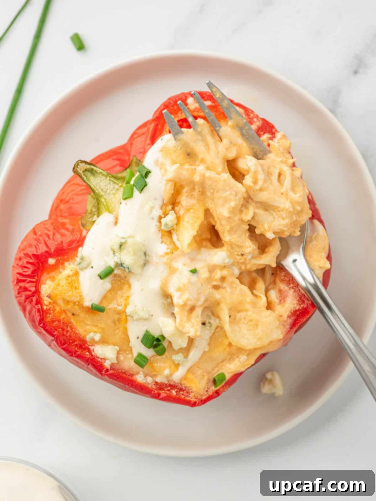 A single buffalo chicken stuffed pepper presented on a plate with a fork, ready to be enjoyed.
