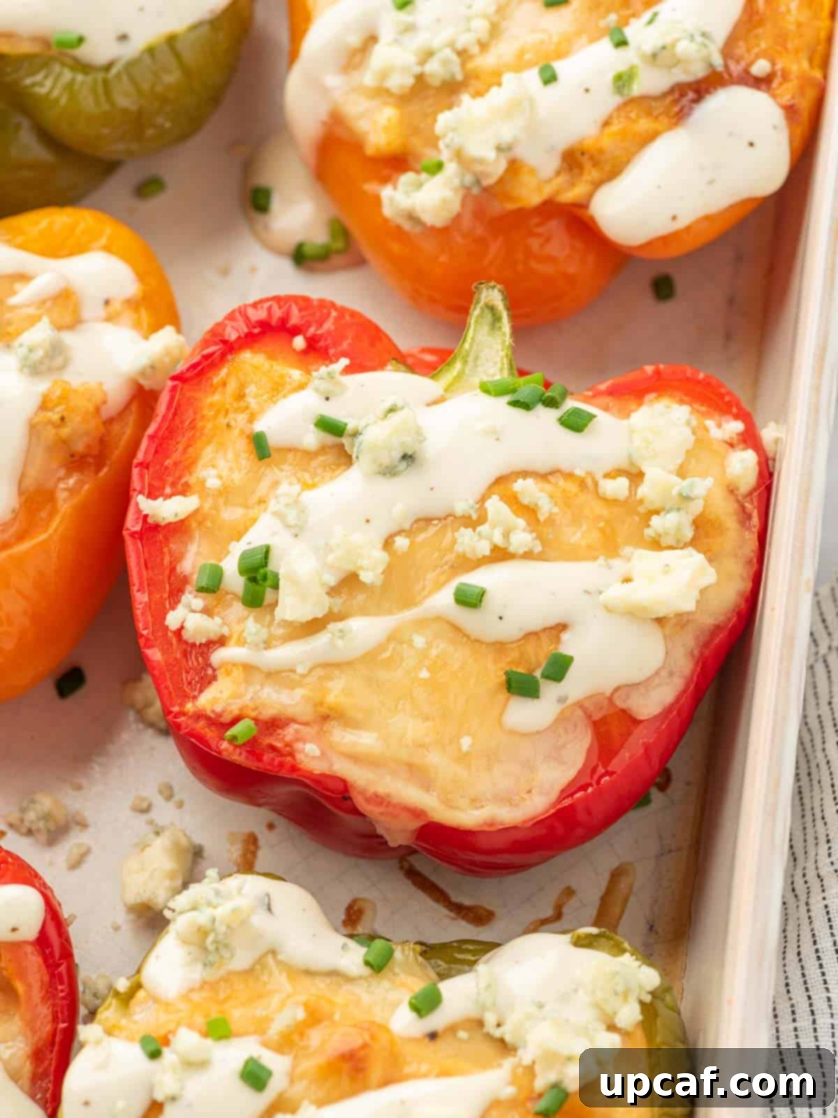 A close-up shot of buffalo chicken stuffed peppers beautifully arranged in a baking dish, highlighting the creamy filling and melted cheese.