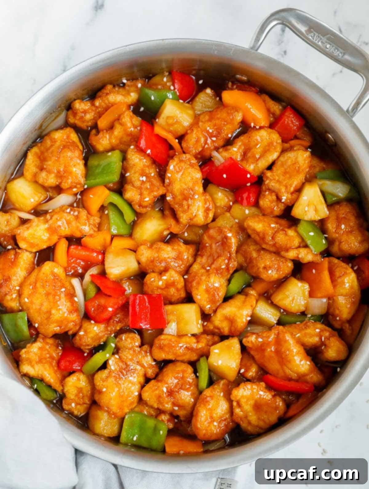 Crafting Delicious Sweet and Sour Chicken at Home 12 Chicken tossed with easy sweet and sour sauce in a skillet.