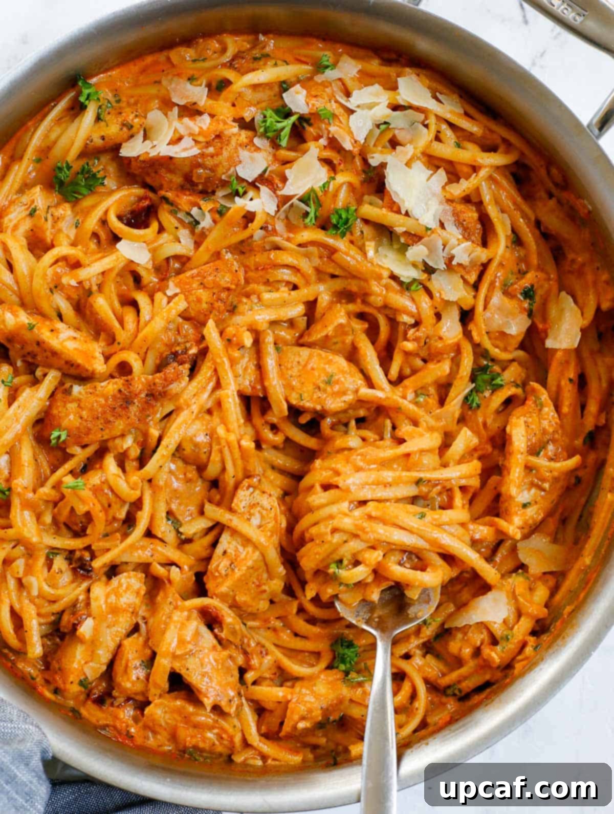 Creamy spicy chicken pasta simmering in a skillet, ready to be served.