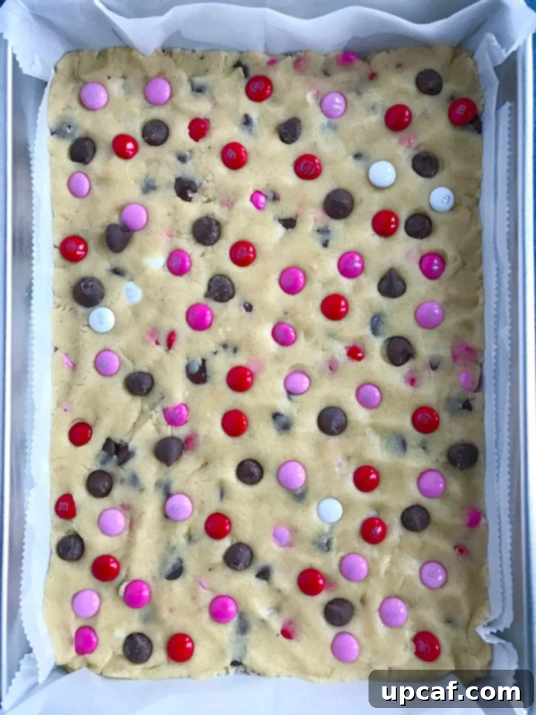 Cookie dough with chocolate chips and M&M's, ready for baking.