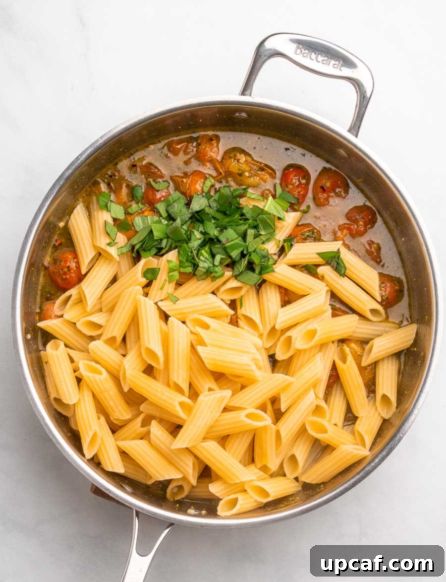 Bursting Cherry Tomato Pesto Pasta 8 top down shot of the cherry tomato pasta in the skillet after pasta and basil are placed in