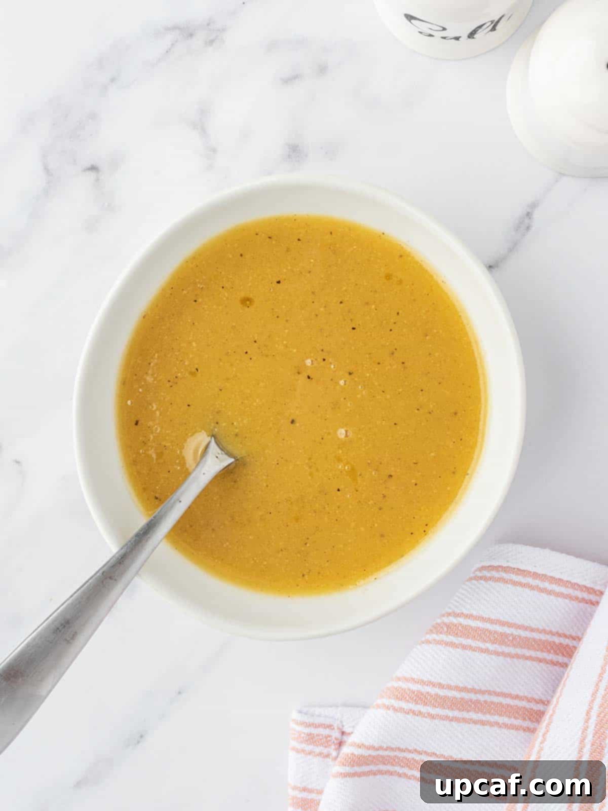 Fall Harvest Chopped Chicken Salad 4 Close-up view of the maple Dijon dressing being prepared in a small bowl, showcasing its smooth texture.