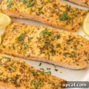 Zesty Lemon Pepper Salmon 9 Lemon pepper baked salmon on a platter with lemon slices.