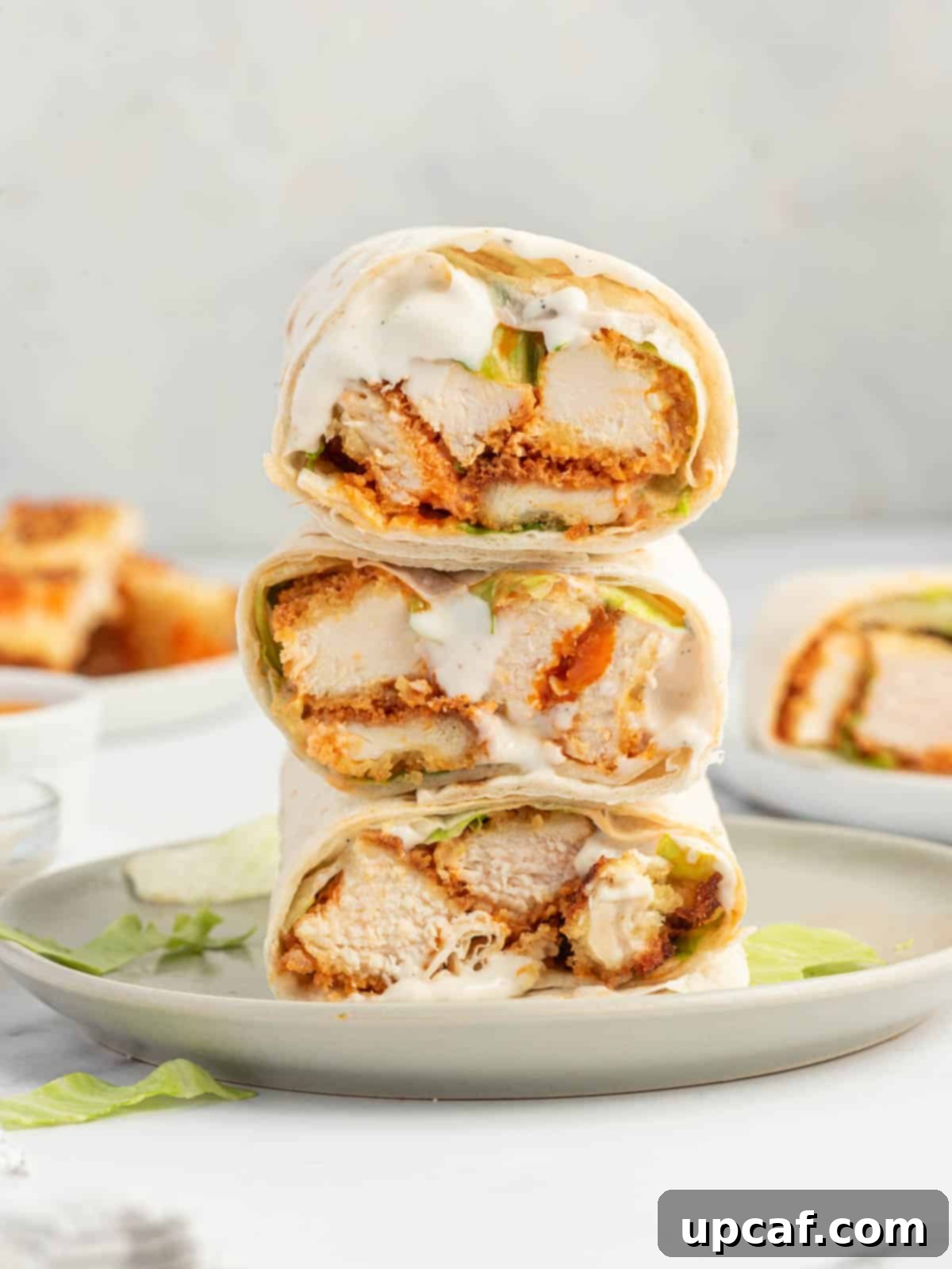 Buffallo chicken tortilla easy lunch wrap on a white plate, showcasing its vibrant ingredients and inviting presentation.