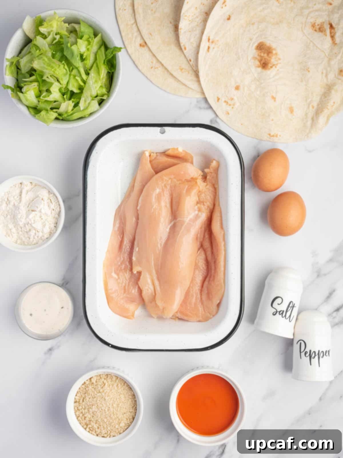 A vibrant selection of fresh ingredients laid out for making crispy buffalo chicken wraps.