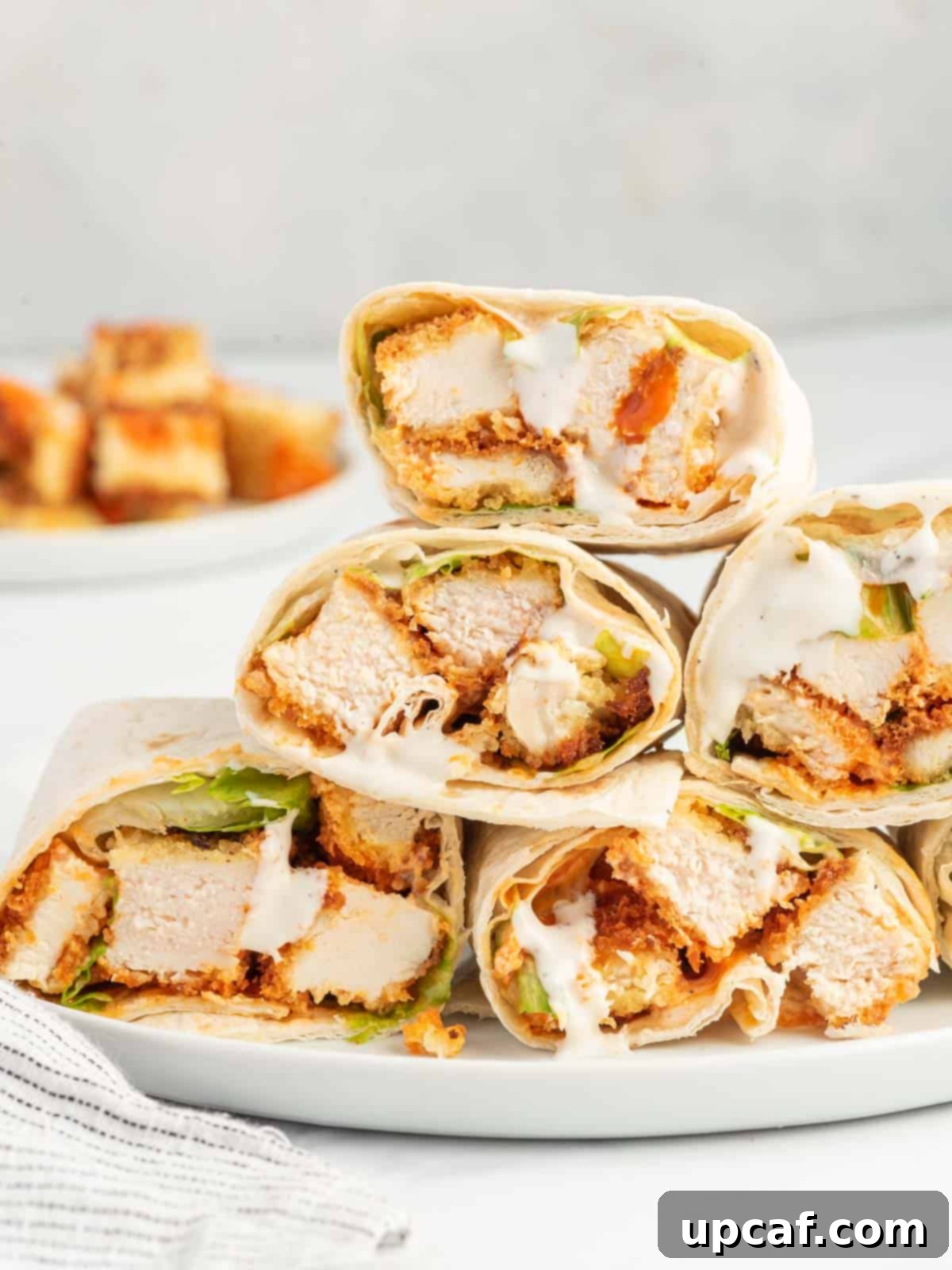 A beautifully arranged platter of spicy chicken wrap sandwiches, sliced and ready to serve.
