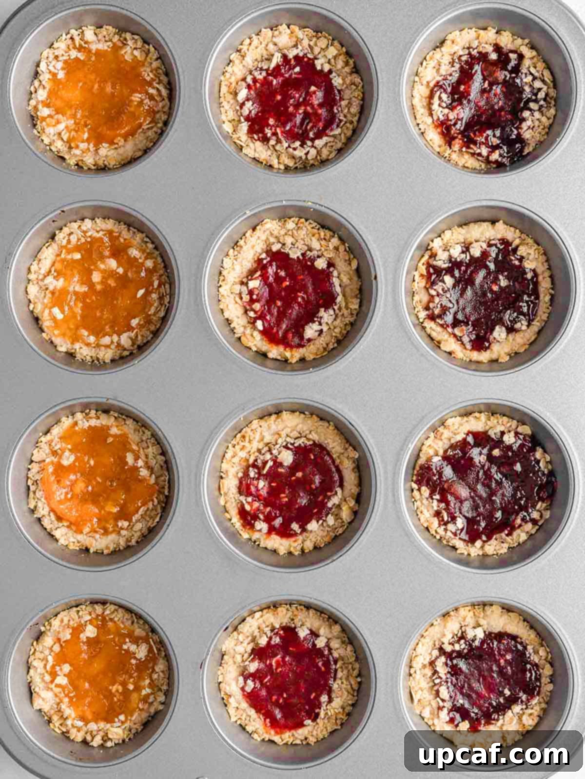 Baked jam filled cookies in a muffin tin.