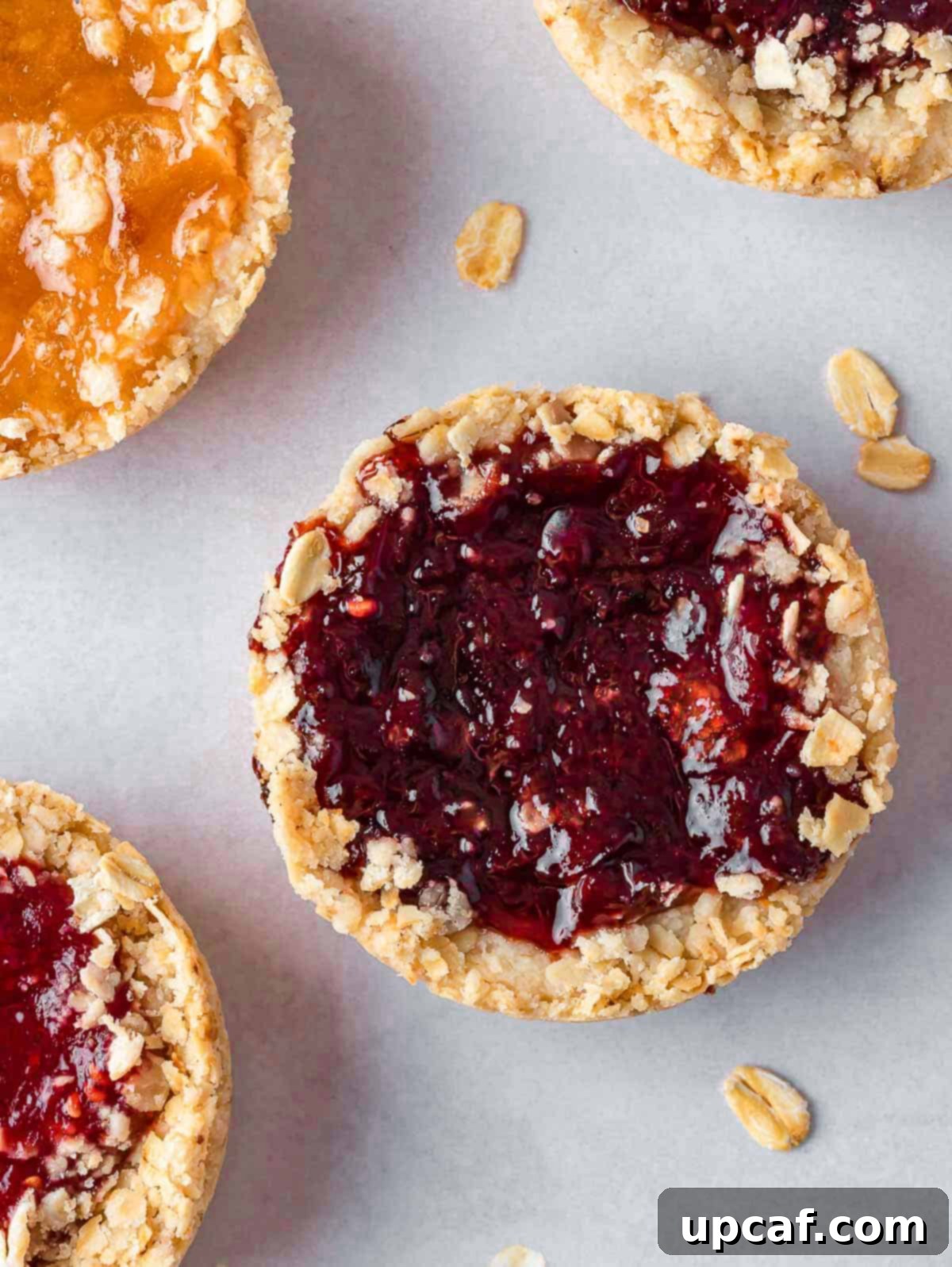 closeup of jam filled cookie on a tray.