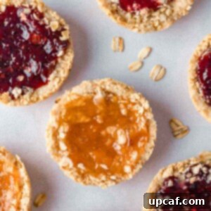 Several oatmeal jam cookies on a tray.