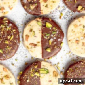 Chocolate dipped pistachio cookies on a tray.