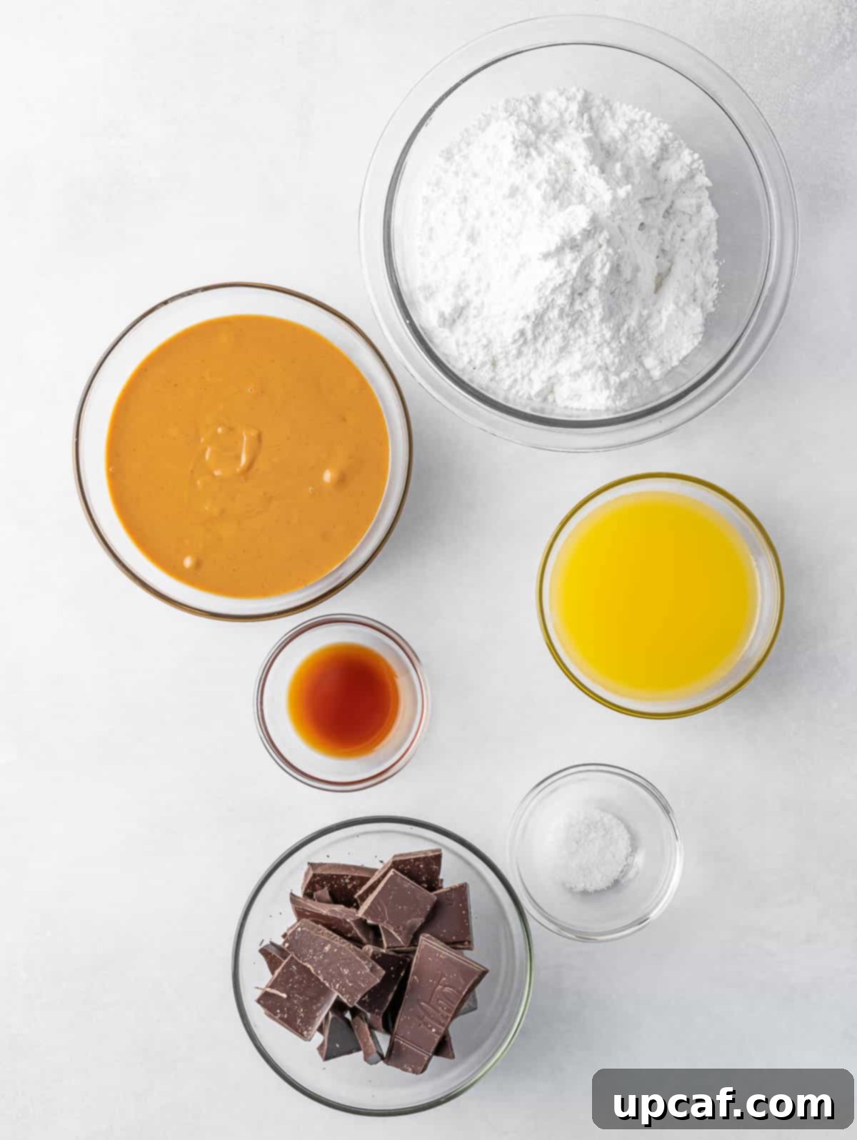 Buckeye Peanut Butter Temptations 3 A collection of ingredients laid out, including peanut butter, powdered sugar, butter, vanilla extract, and chocolate, ready for making buckeye balls.