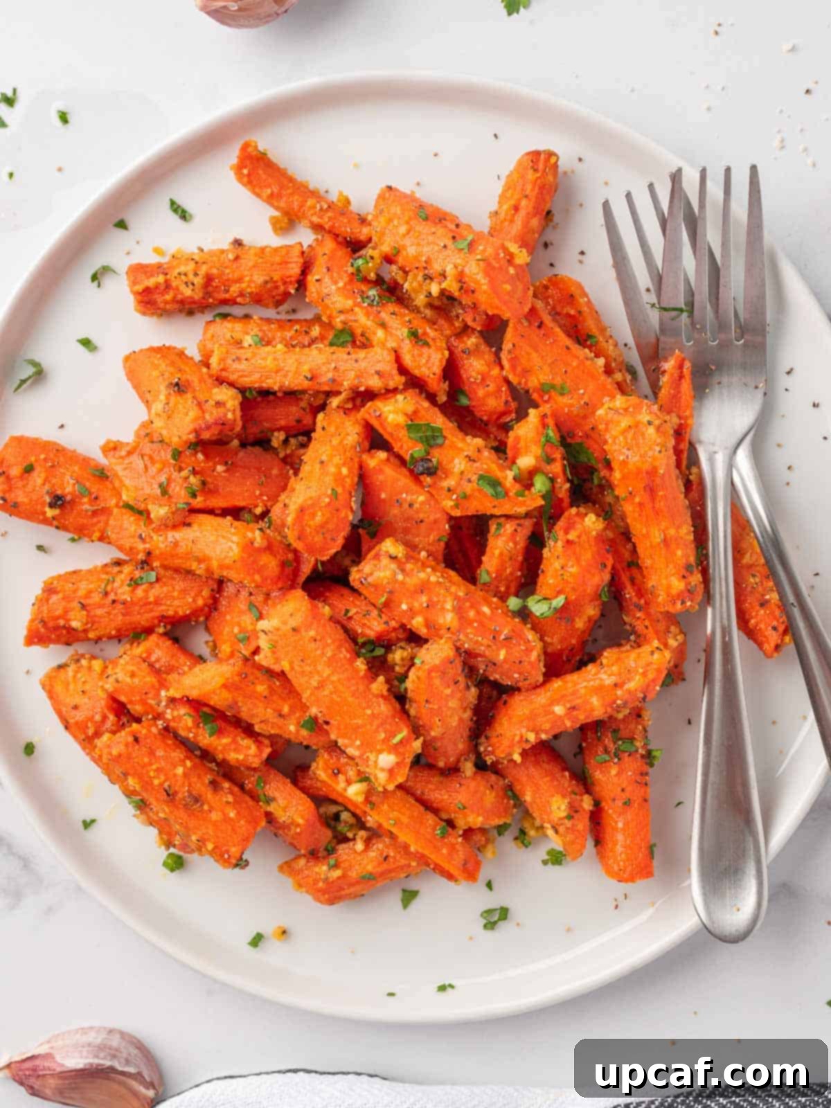 golden and flavorful roasted carrots with parmesan cheese on a plate, ready to be served.