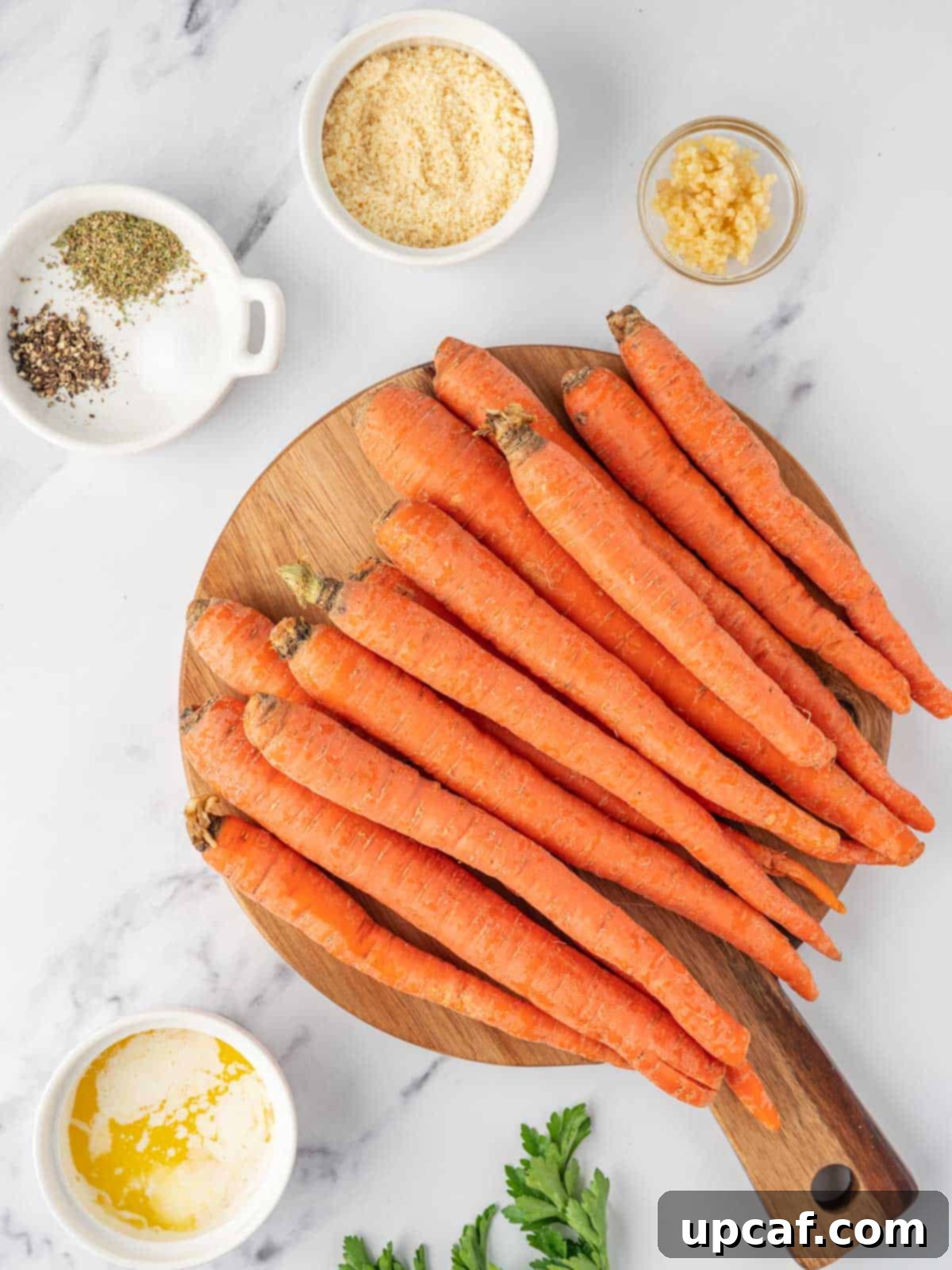 Ingredients needed for parmesan roasted glazed carrots, including fresh carrots, butter, garlic, herbs, and cheese.