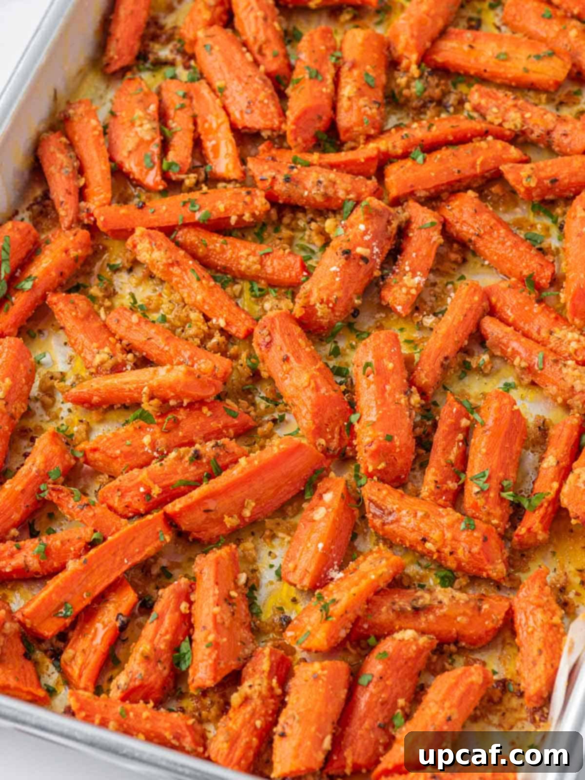 Oven roasted carrots with parmesan cheese, fresh from the oven, on a baking tray.