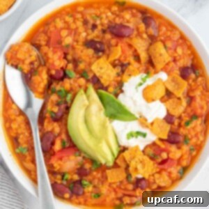Hearty Plant-Based Lentil Chili 9 Delicious vegan bean chili topped with crunchy fritos, creamy avocado, and a dollop of vegan sour cream, ready to be served.