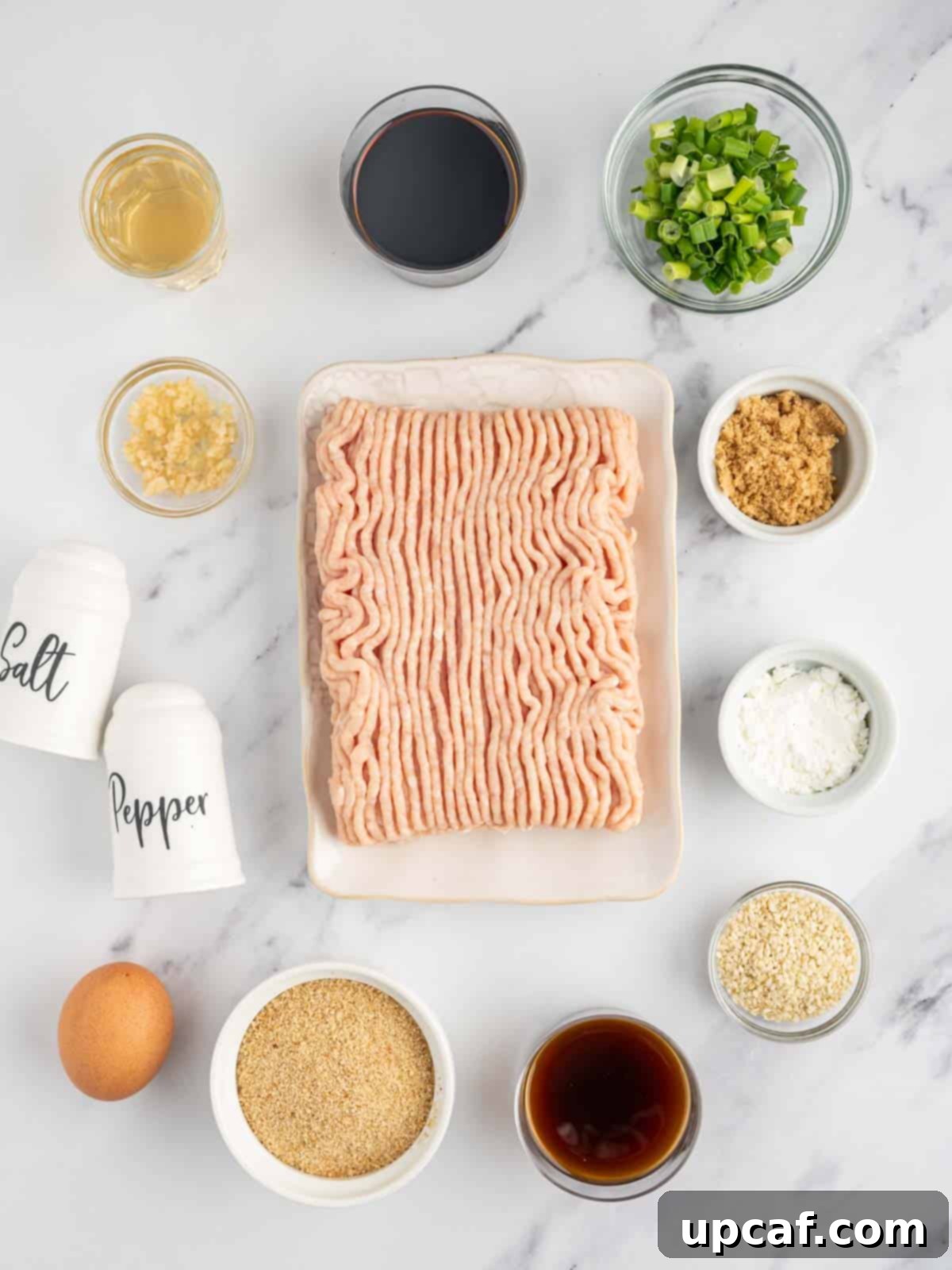 Various ingredients for teriyaki chicken meatballs laid out on a table.