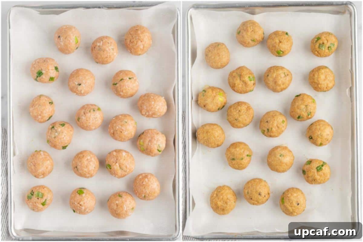 Baked chicken meatballs arranged on a parchment-lined baking sheet.