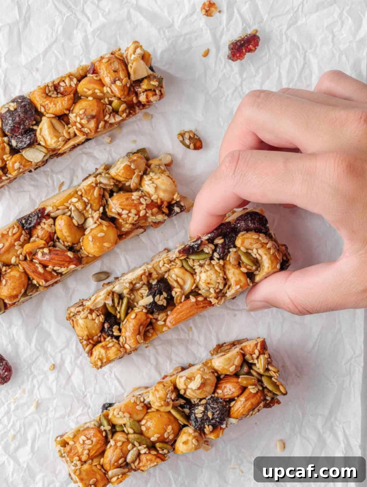 A hand picks up a seed and nut bar.