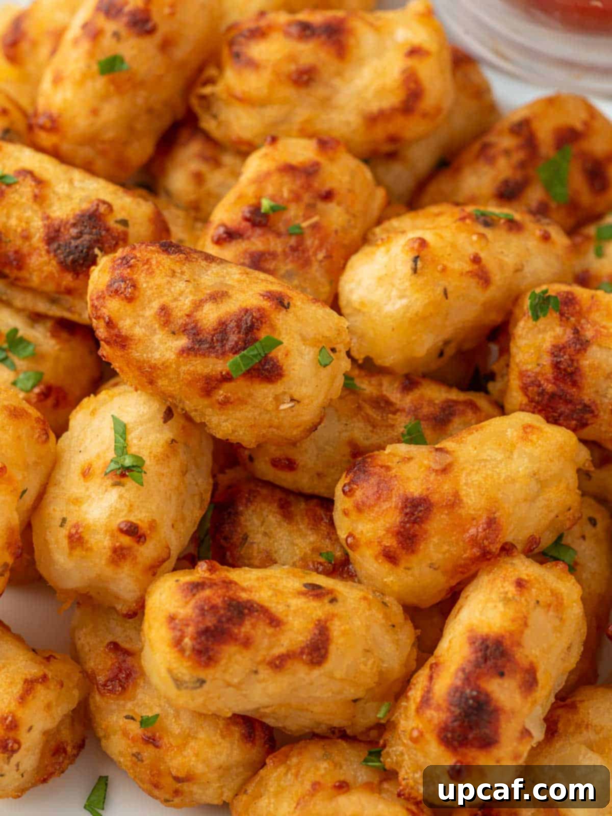 Gooey Crispy Air Fried Tater Tots 10 Close up of cheesy tater tots in a pile.