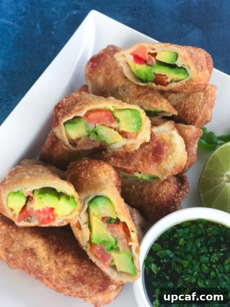 Golden brown Avocado Egg Rolls on a serving plate, ready to be enjoyed as a gourmet appetizer.