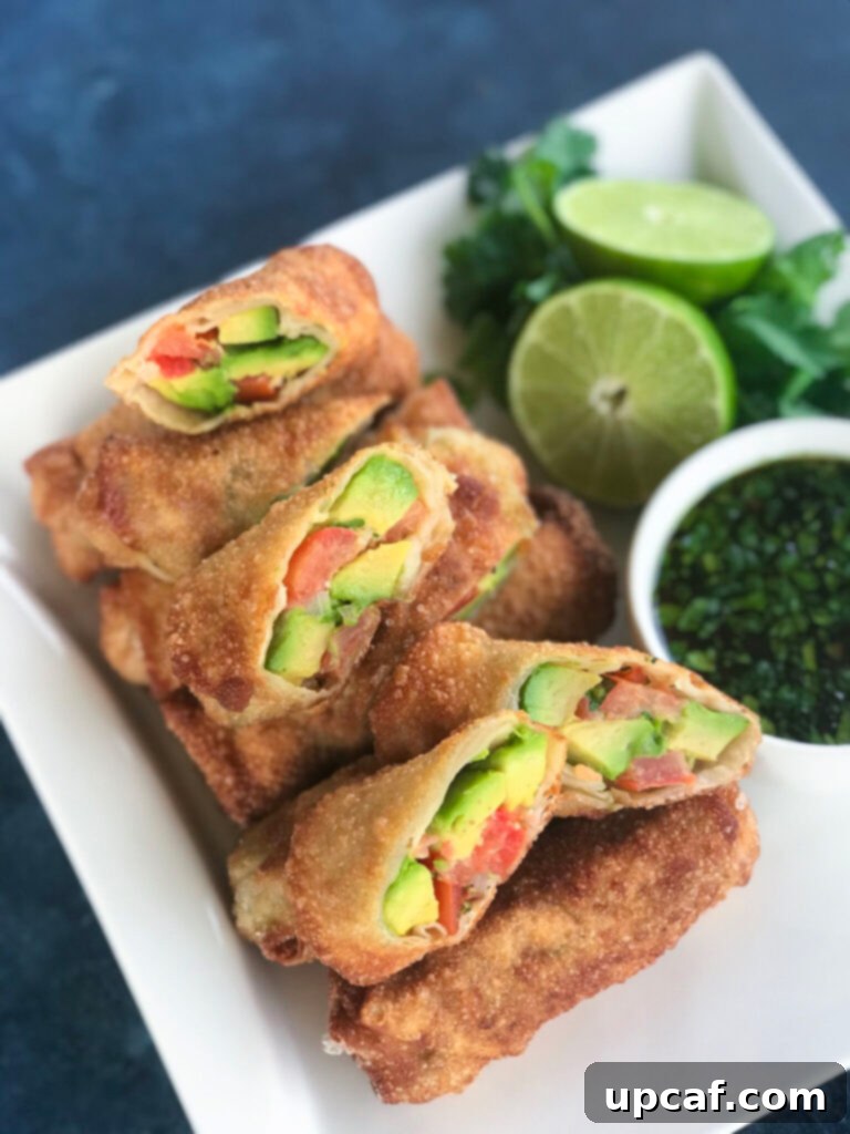 Top-down view of freshly prepared Avocado Egg Rolls arranged beautifully on a plate with dipping sauce.