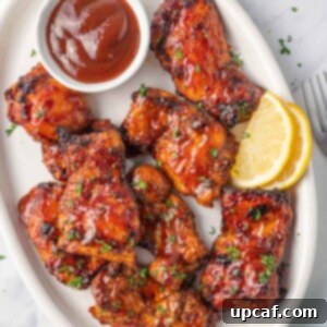 Air fryer bbq chicken on a plate with extra barbecue sauce.