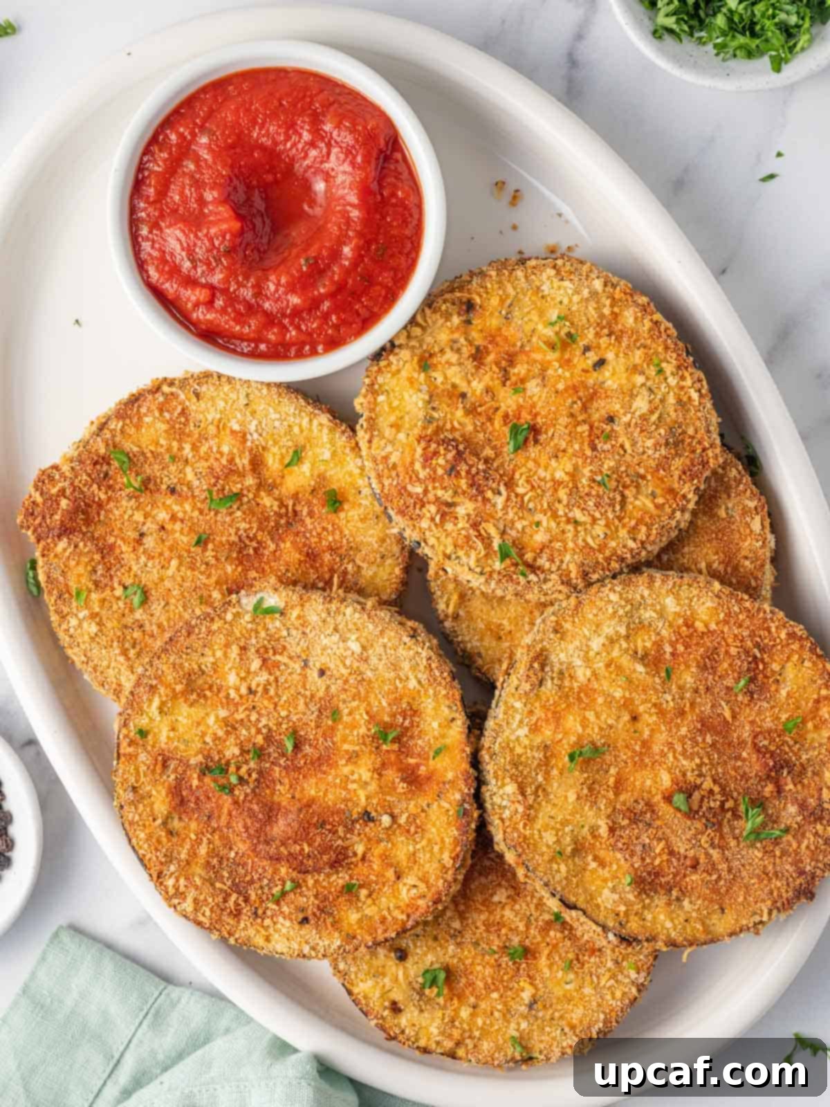 A platter of air fried eggplant with marinara.