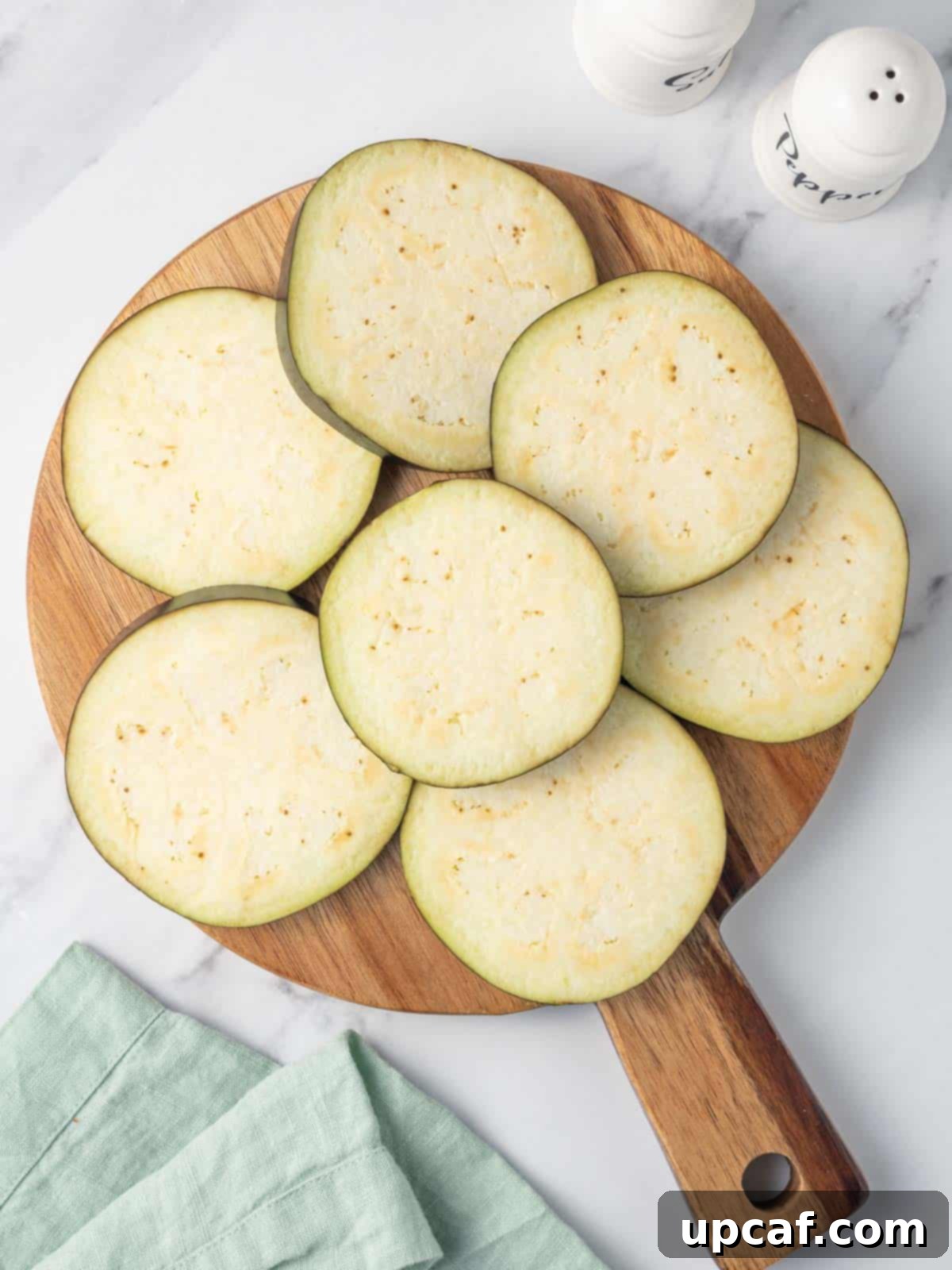 Slices of eggplant on a board.