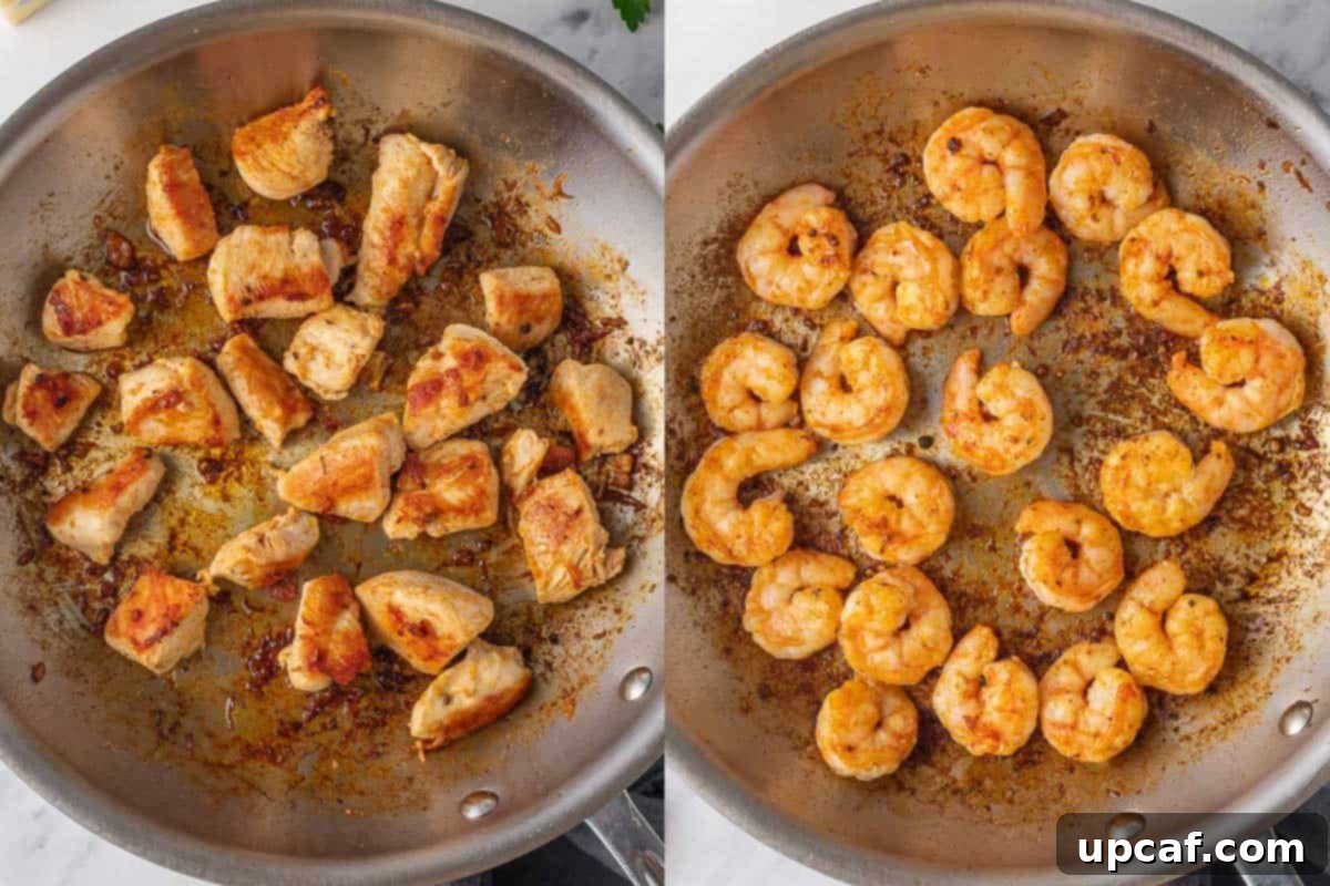 Sautéing chicken and shrimp in a skillet.
