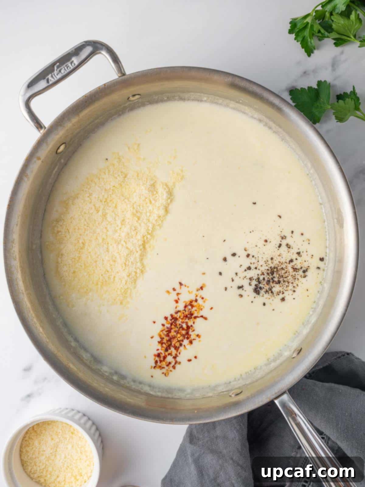 Preparing creamy alfredo sauce in a skillet.