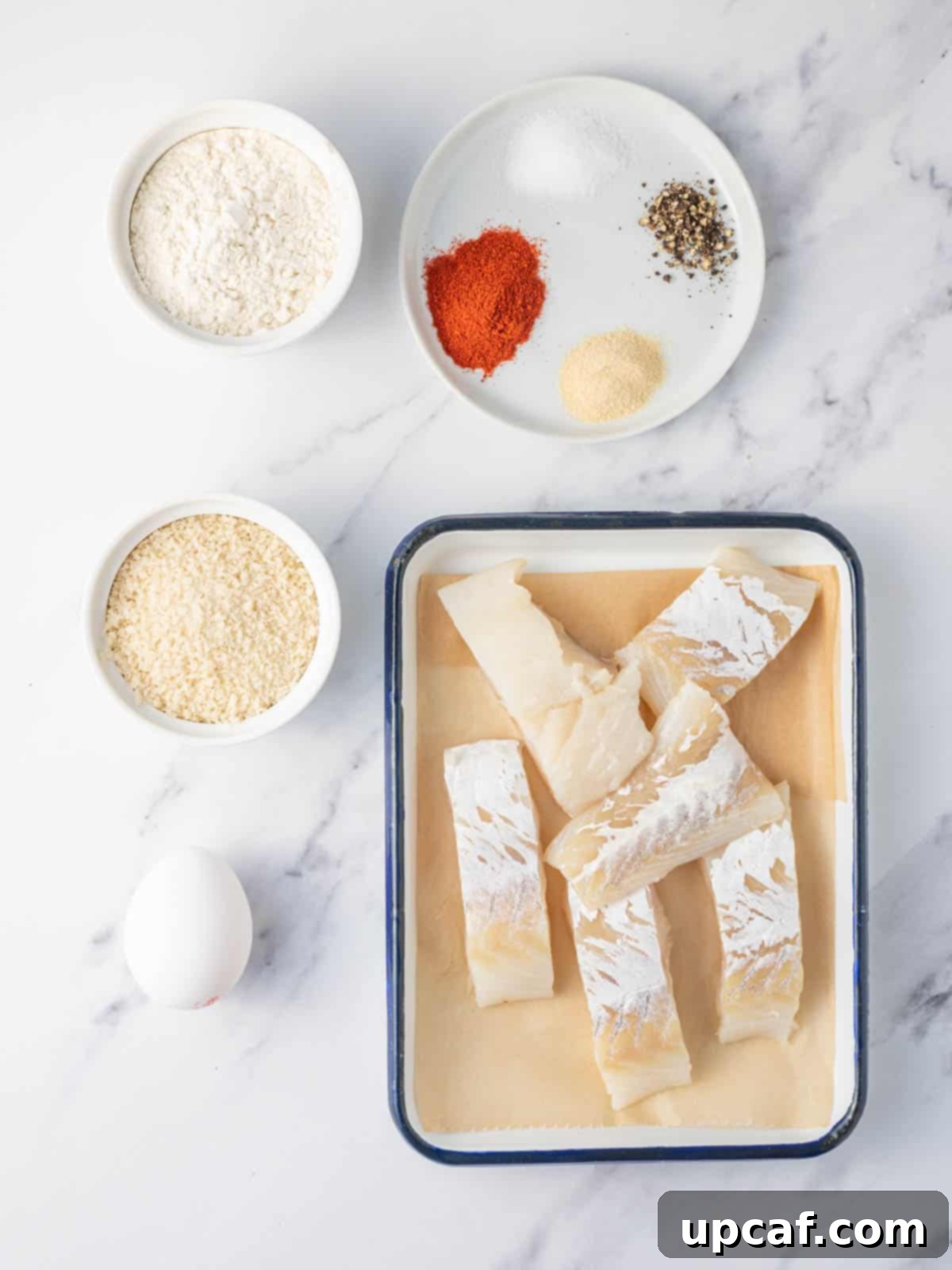 Guilt-Free Crispy Air Fryer Fish and Chips 3 Assortment of ingredients for air fryer fish and chips: cod, flour, spices, egg, panko, parsley, lemon.
