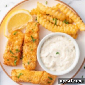 Guilt-Free Crispy Air Fryer Fish and Chips 8 A plate of fish and chips with tarter sauce.