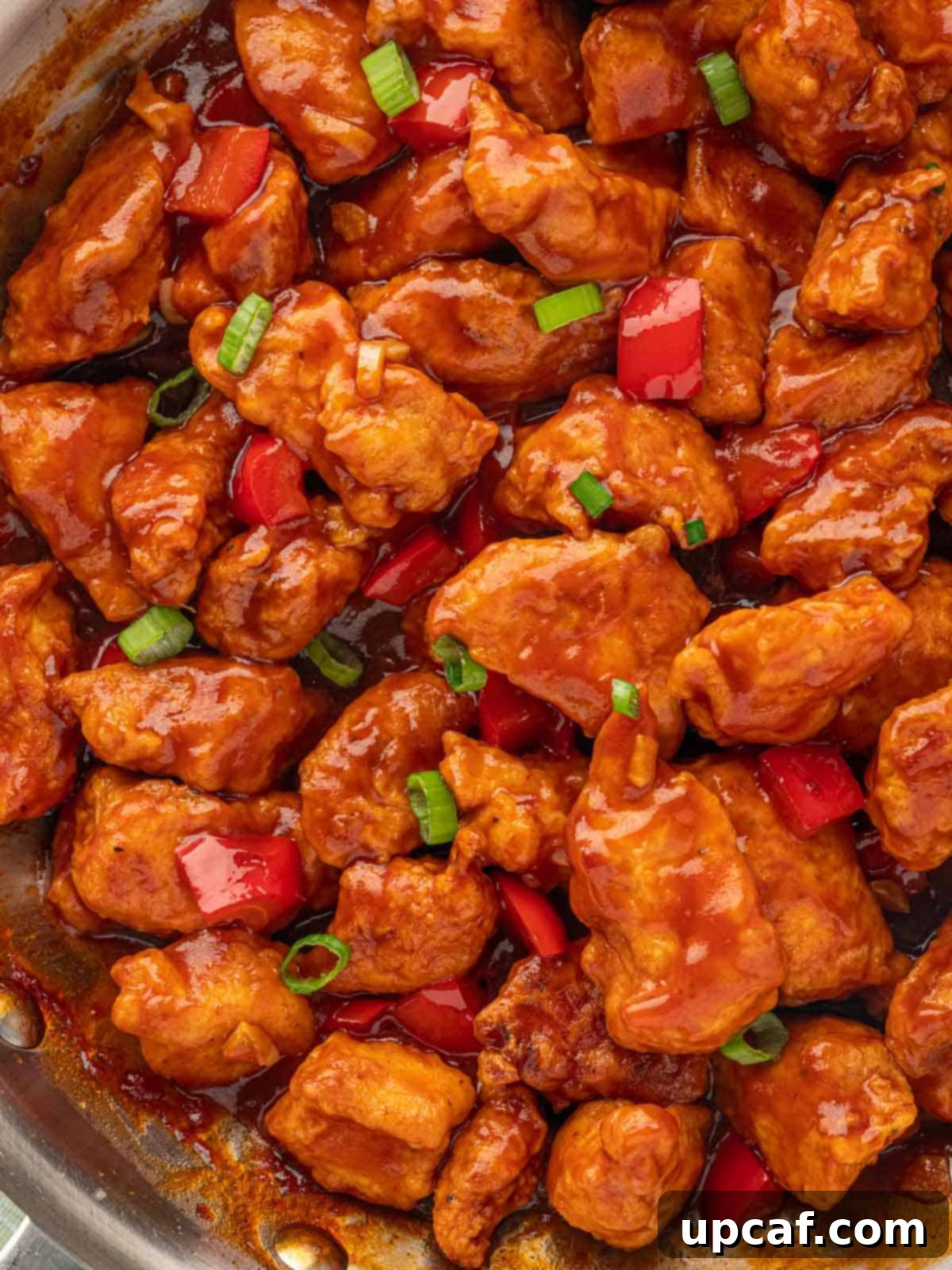 Crispy Garlic Chili Chicken 8 A close-up shot of an Indian-style chicken recipe, showcasing the rich, reddish sauce and tender chicken pieces.