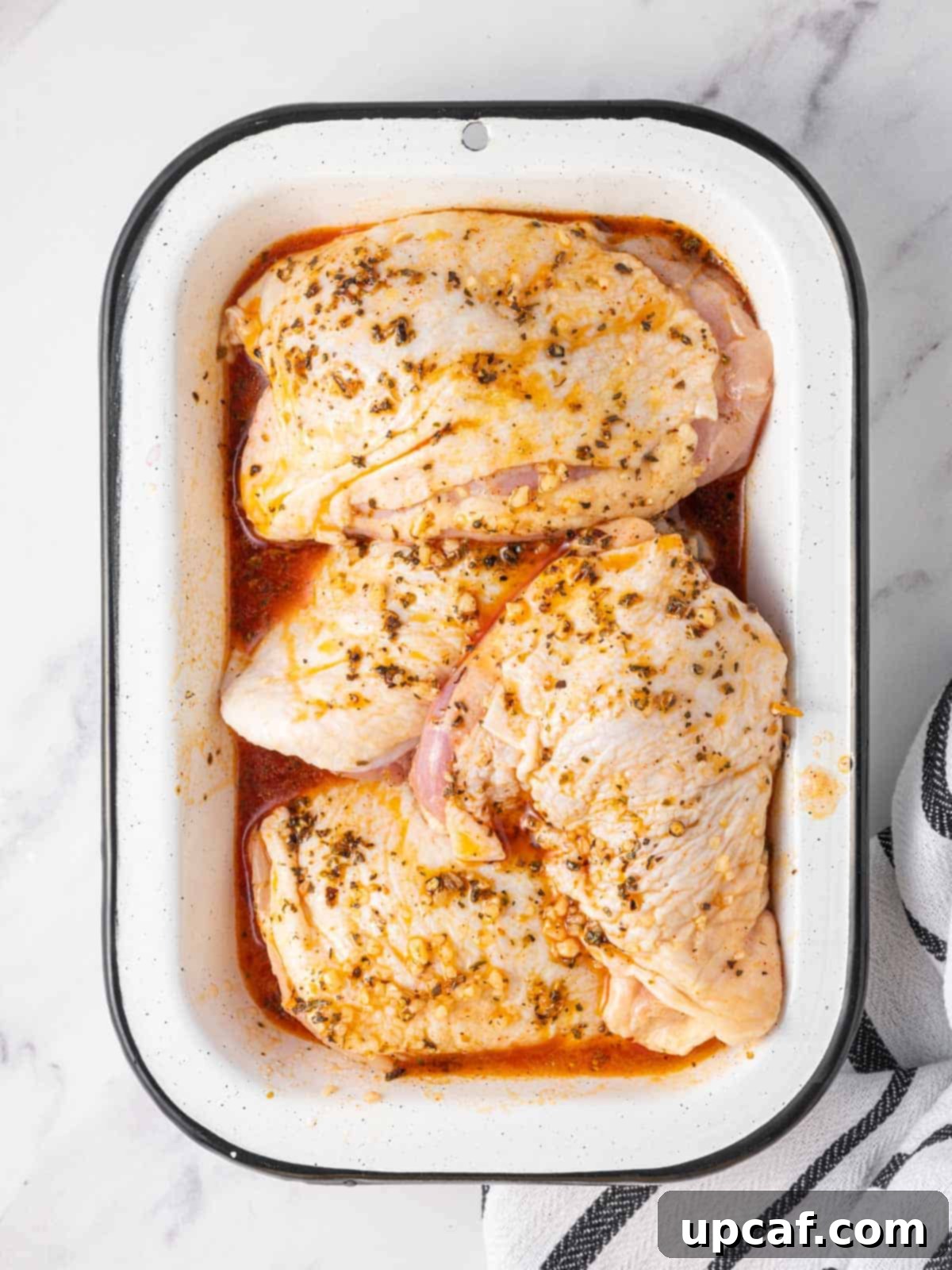 Chicken marinating in a dish.