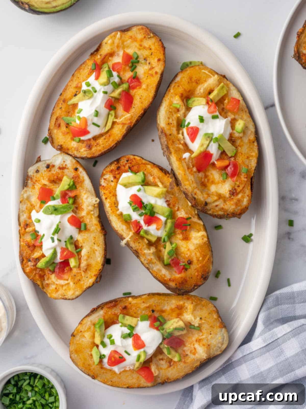 Crispy Air Fryer Potato Skins 2 A plate of cheesy air fryer potato skins.