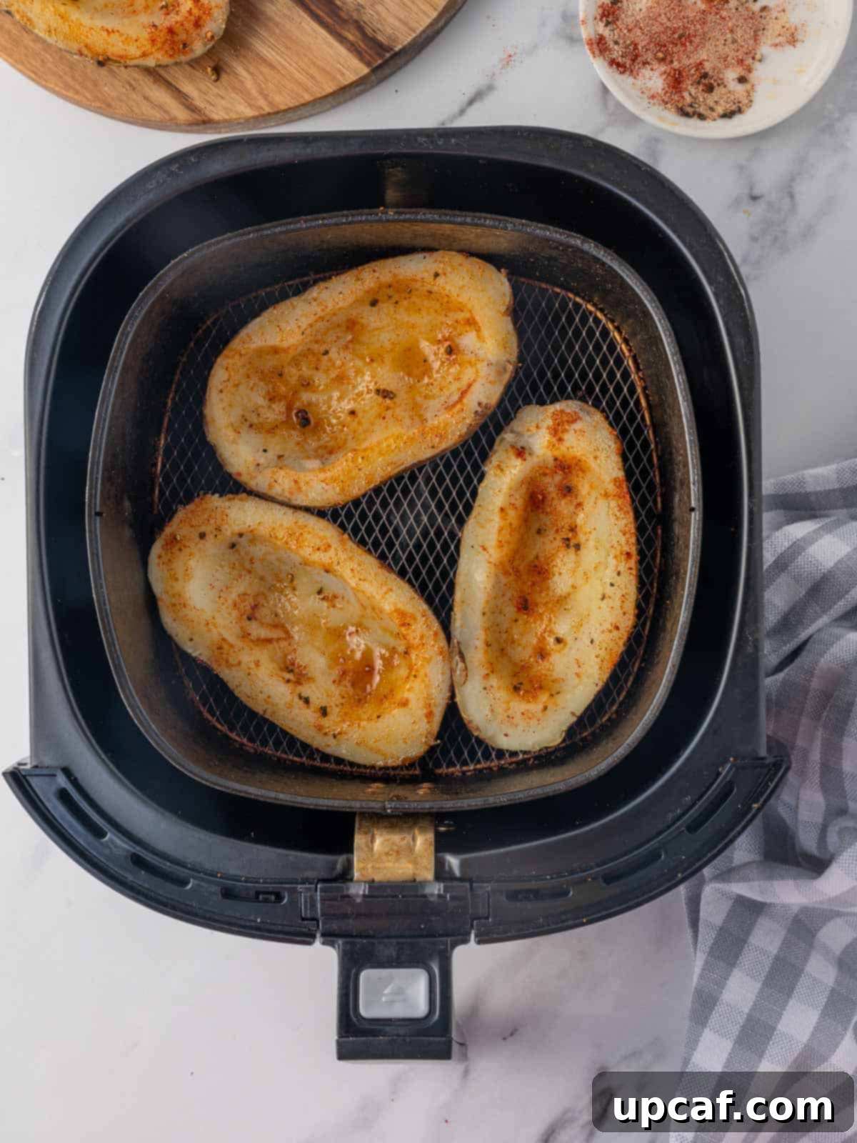 Crispy Air Fryer Potato Skins 5 Seasoned potato skins in an air fryer basket.