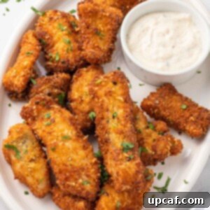 A plate of crispy fried fish with dip.