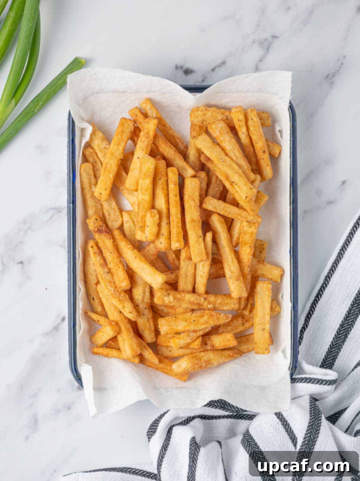 Spicy Honey Glazed Potatoes 5 Cooked fries drain on a paper towel.