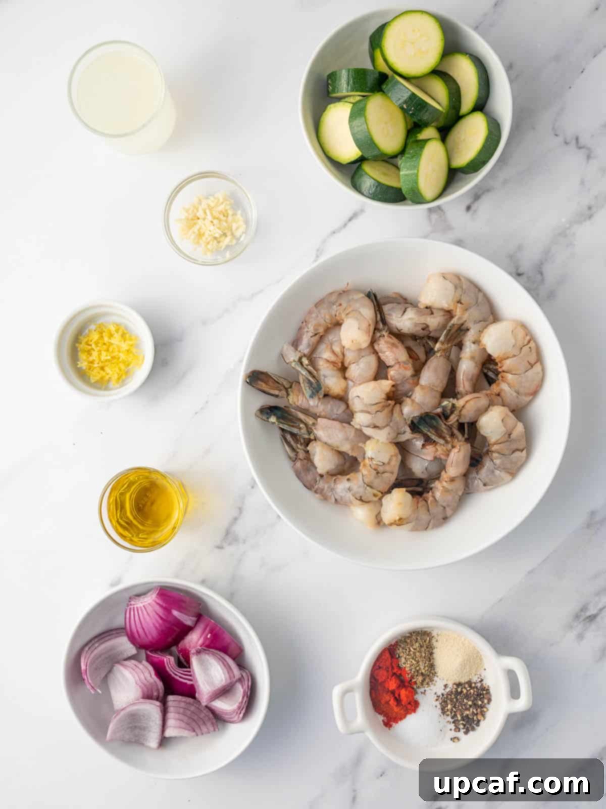 Golden Oven Shrimp Skewers 3 Ingredients needed for marinated greek shrimp skewers, laid out on a table.