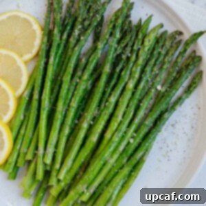 A plate of asparagus with lemon slices, ready to be served.