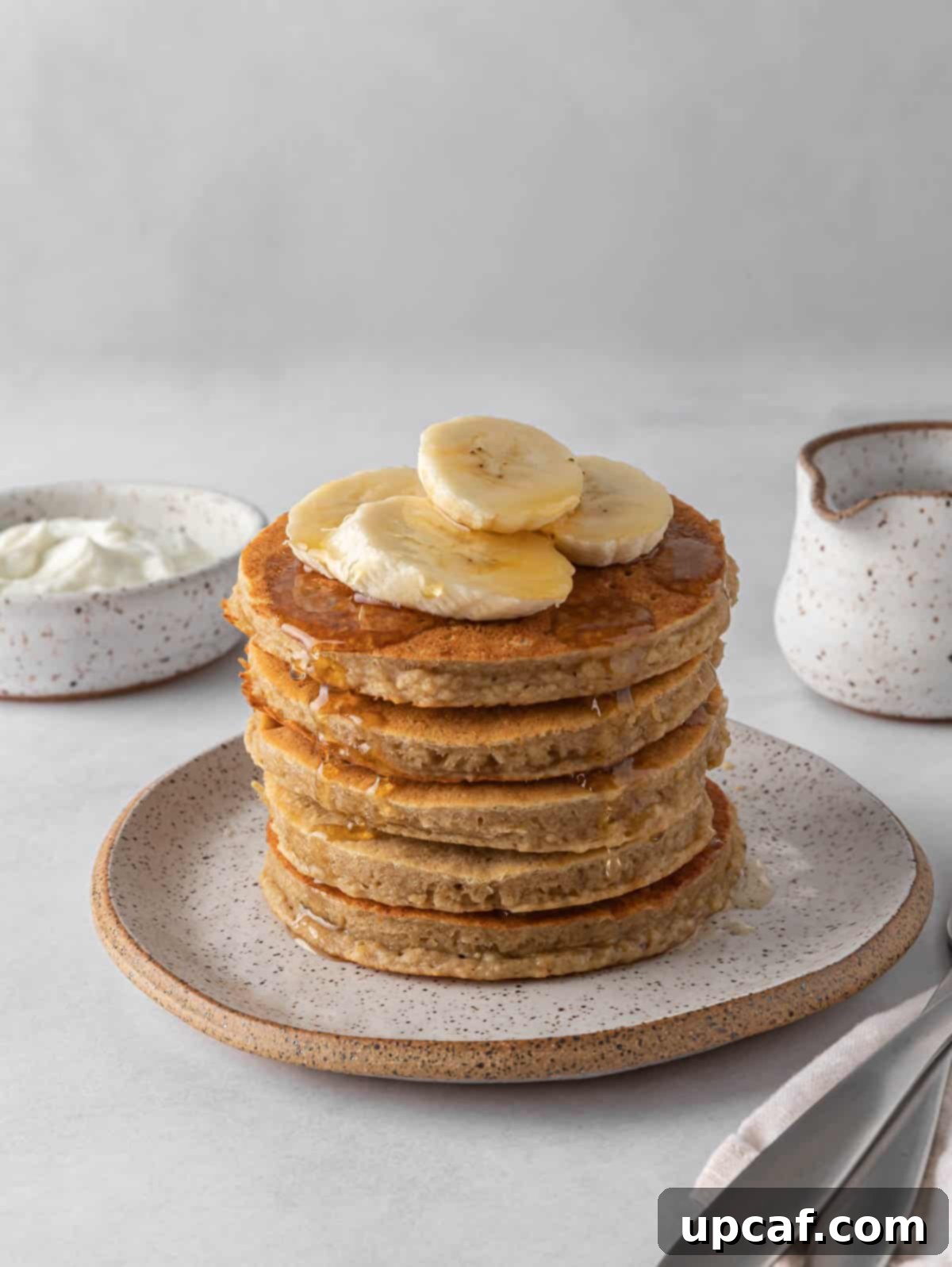 A stack of protein pancakes topped with banana slices.