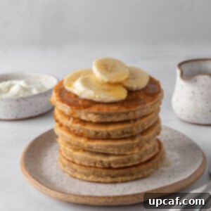 A stack of protein pancakes topped with banana slices.