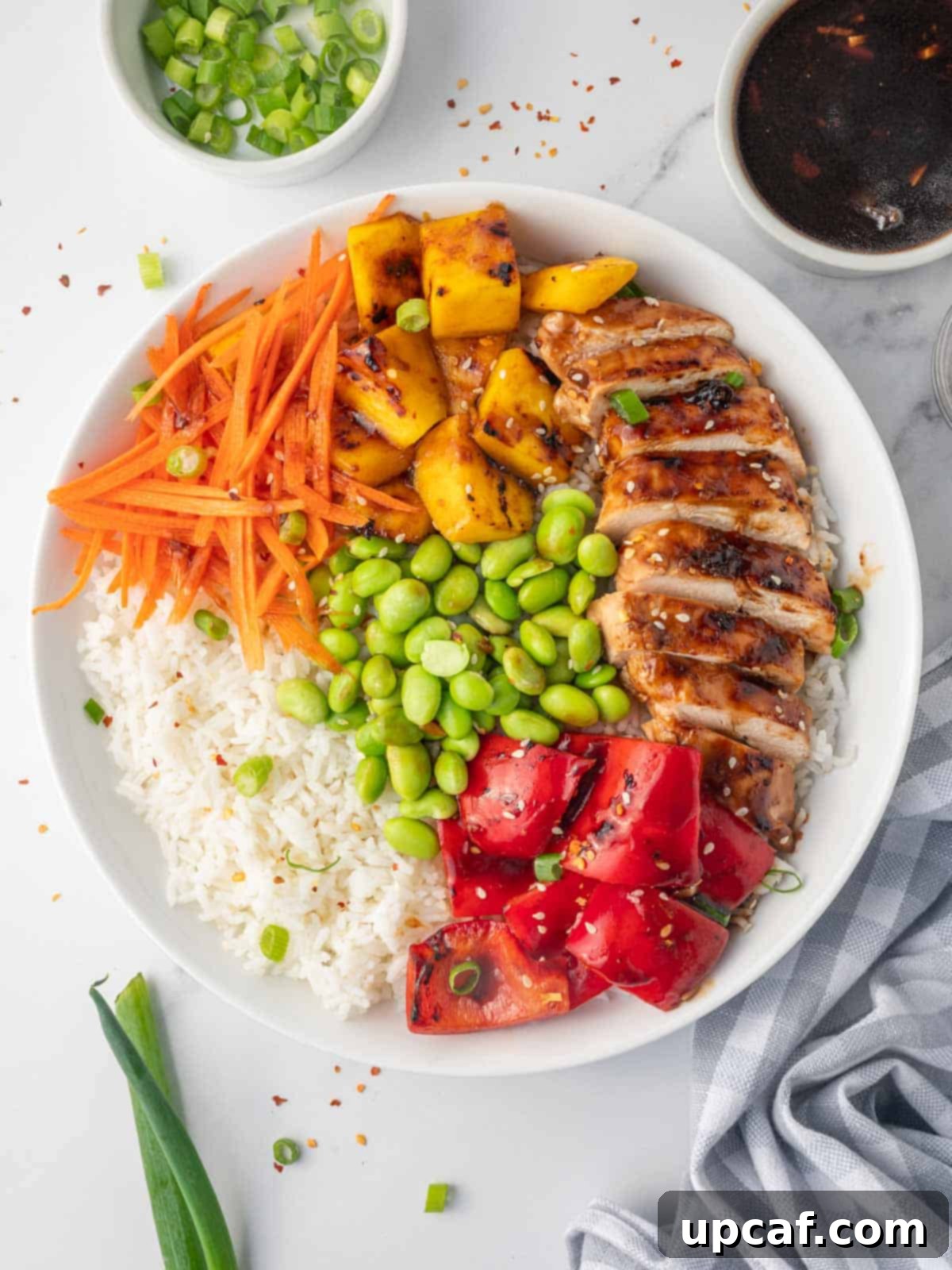 Sweet & Savory Teriyaki Chicken Bowl 2 A vibrant Teriyaki Chicken Bowl, garnished with fresh sesame seeds, chopped green onions, and red chili flakes, featuring tender chicken, steamed rice, and colorful vegetables.