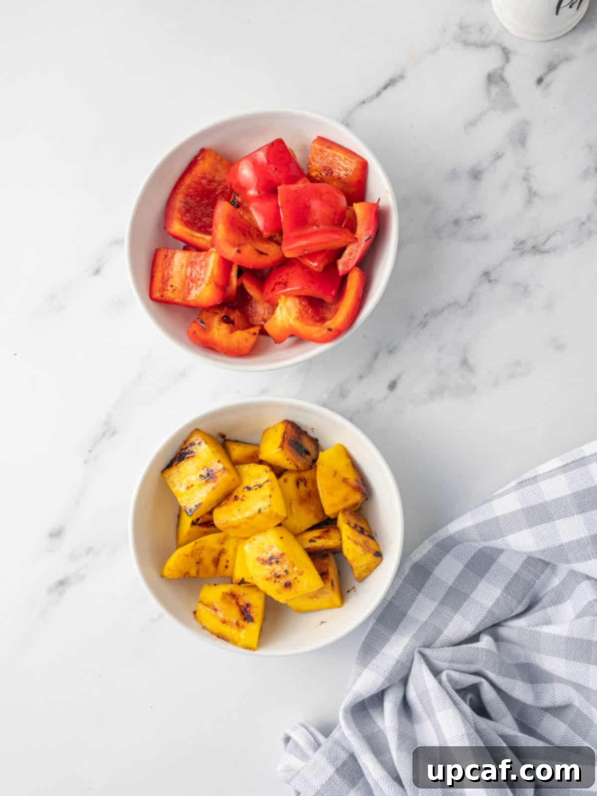 Sweet & Savory Teriyaki Chicken Bowl 6 Two separate bowls filled with sautéed mango chunks and sliced red bell peppers, ready for assembly in a teriyaki bowl.