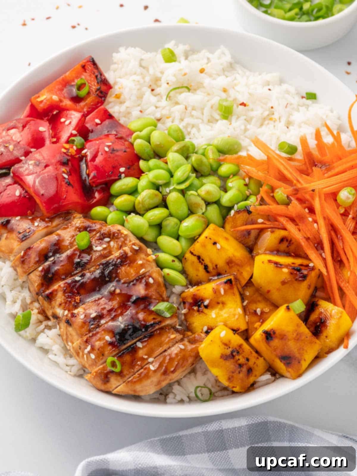 Sweet & Savory Teriyaki Chicken Bowl 7 A close-up view of a perfectly assembled Teriyaki Chicken Bowl, highlighting the marinated chicken, colorful vegetables, and a generous drizzle of glossy sauce over fluffy rice.