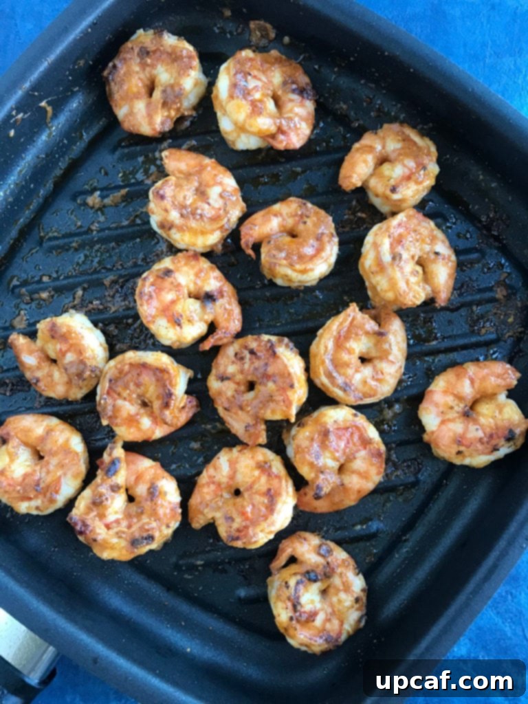 Shrimp cooking in a hot skillet, perfectly seasoned and turning pink