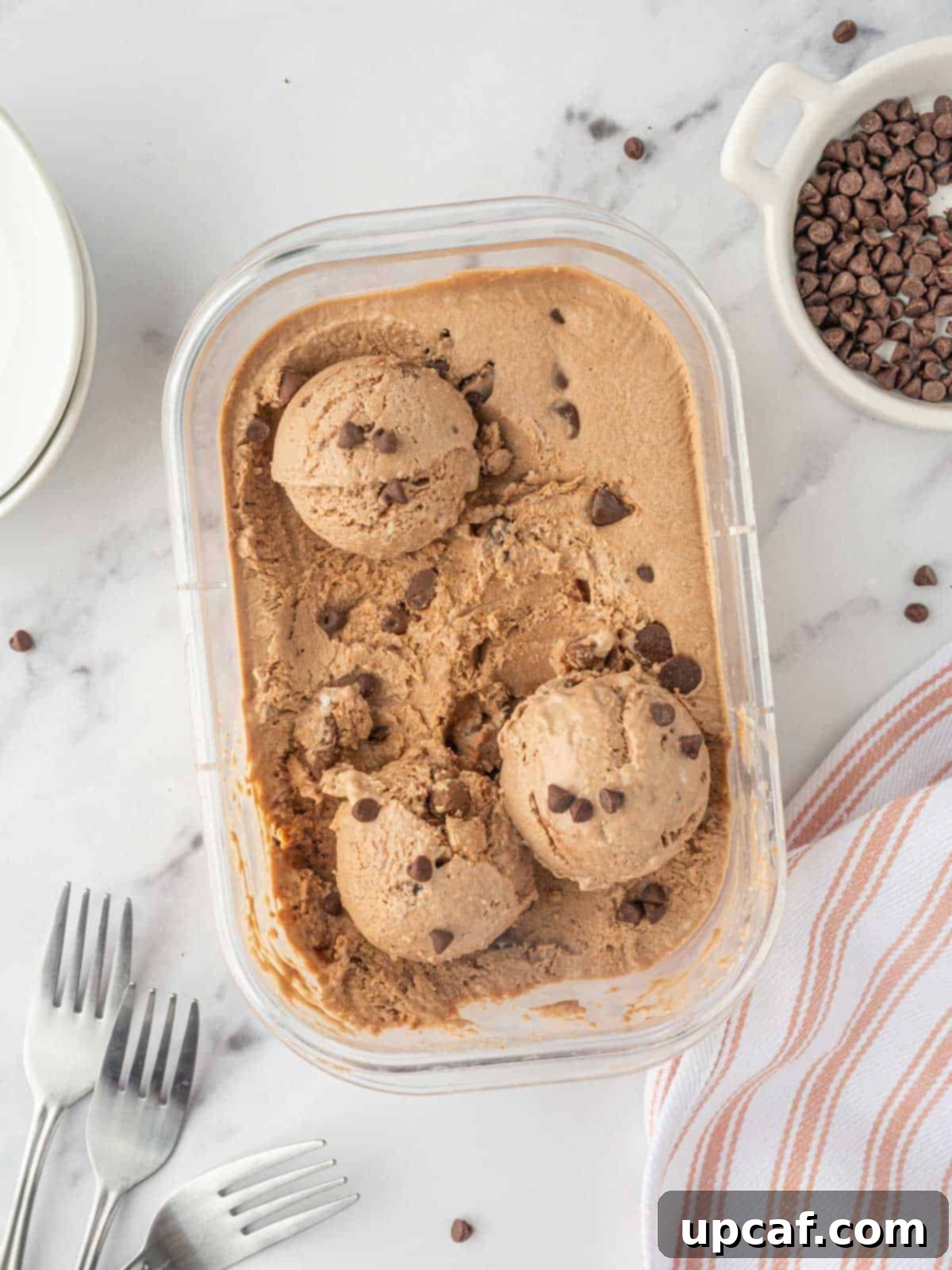 A container of creamy chocolate peanut butter cottage cheese ice cream, showing its rich color and inviting texture.