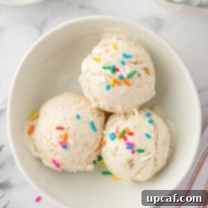 Scoops of vanilla ice cream with rainbow sprinkles in a bowl.