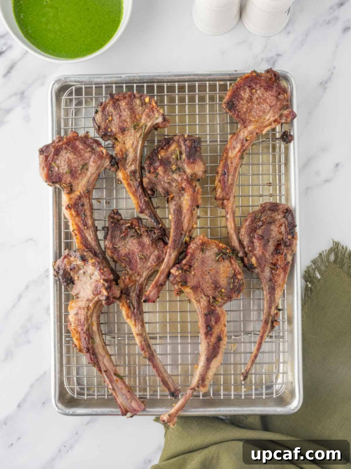 Perfectly grilled lamb chops resting on a wooden platter, ready to be served.